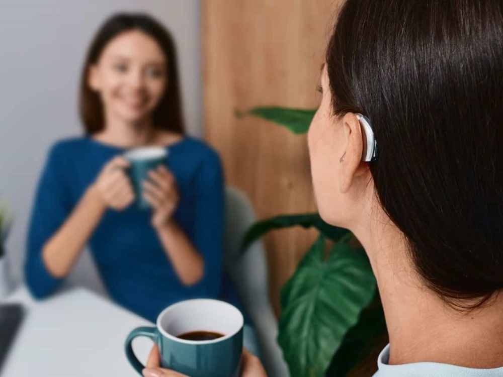 Woman wearing a receiver-in-canal hearing aid, one of the styles fitted at Anne Arundel Audiology in Glen Burnie, MD